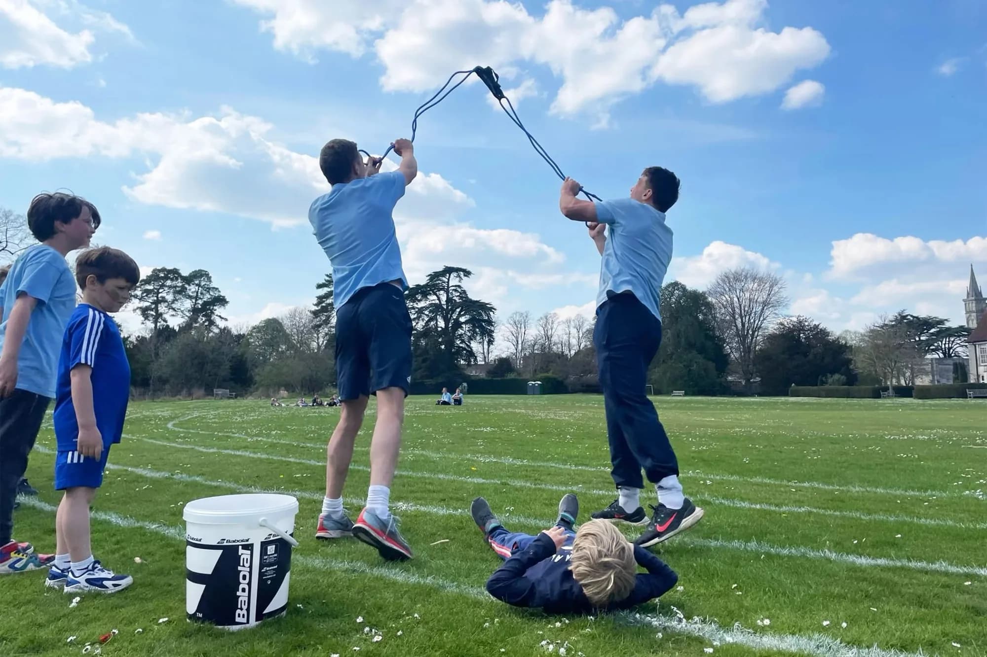 Children and teenagers playing and jumping on a grassy field