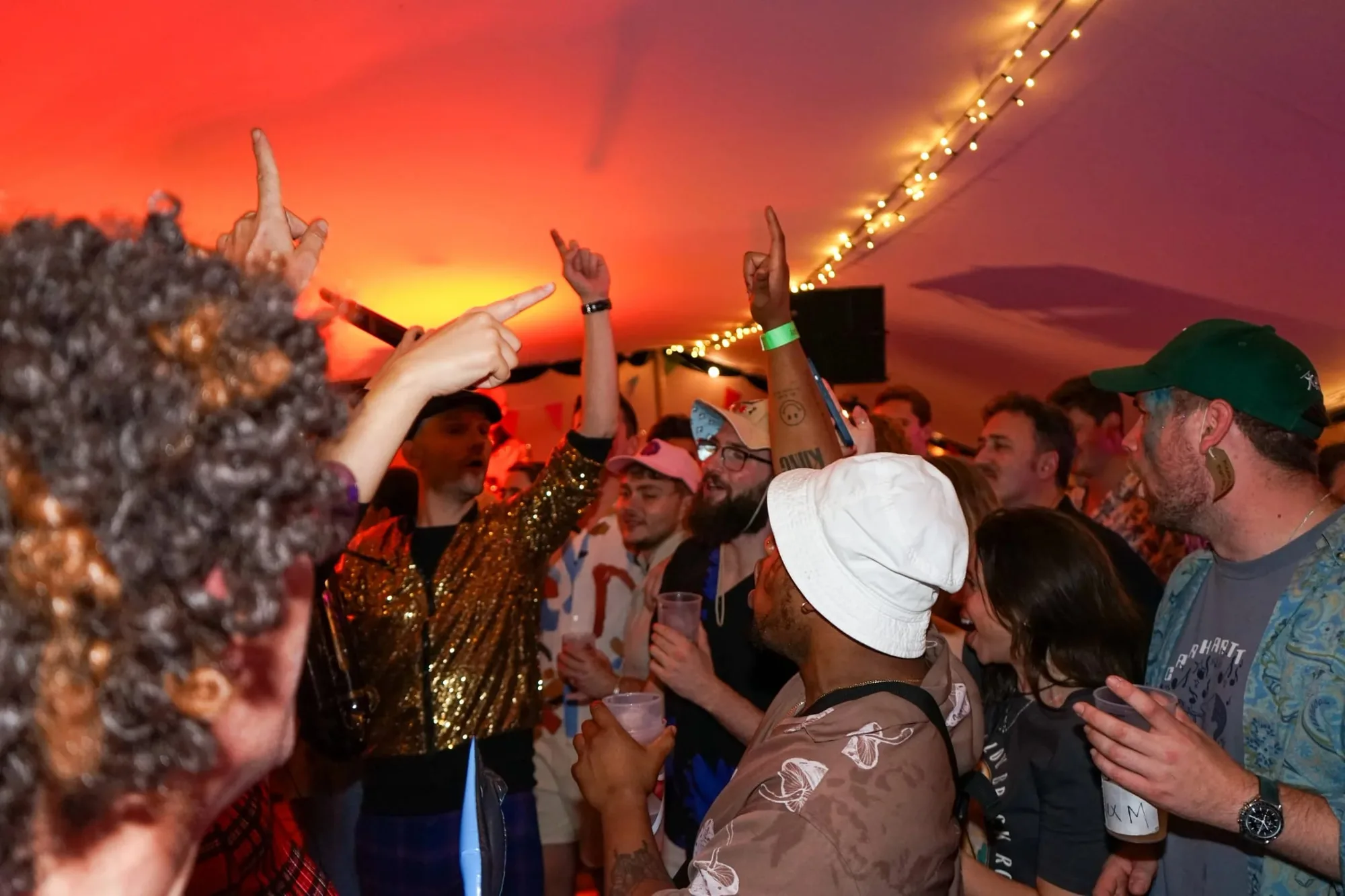 A corporate party in full swing under warm orange lights